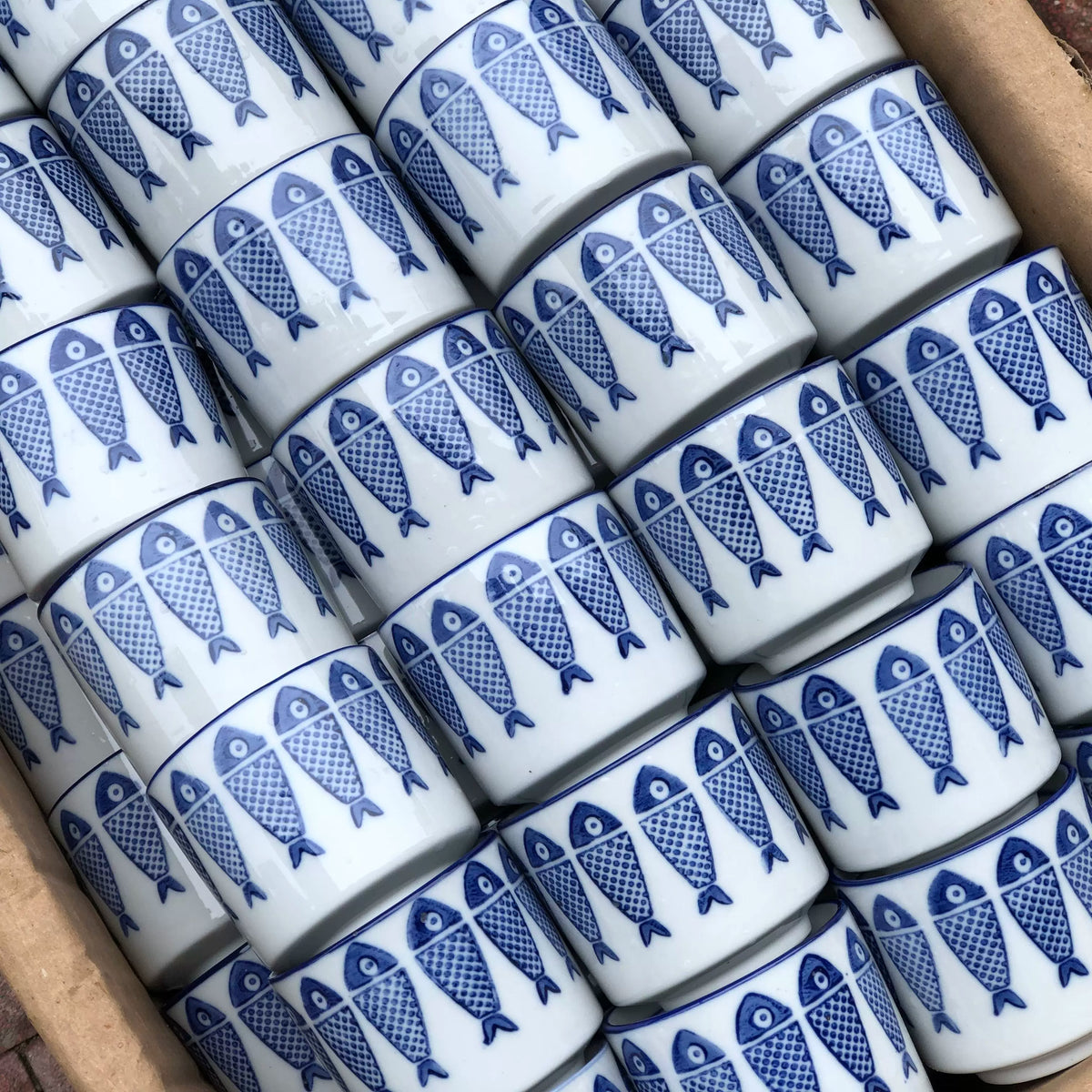 Fish motif and blue rim on a small porcelain teacup