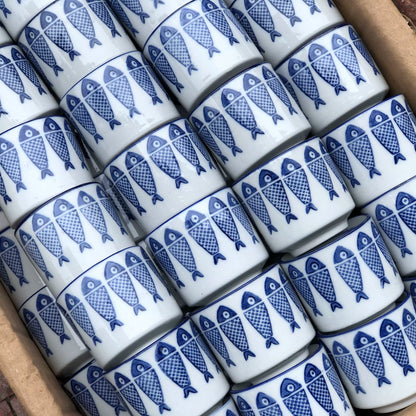 Fish motif and blue rim on a small porcelain teacup