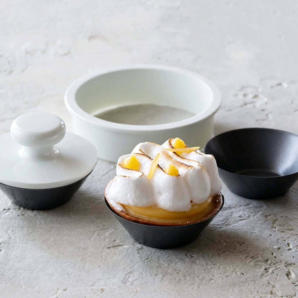 Egg tart cup with white pastry press, round cutter and a finished lemon tart