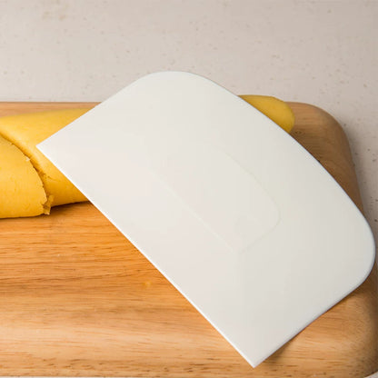White CakeLand 1754 dough and bowl scraper beside pastry dough