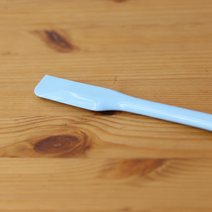 Close-up of the narrow blue head of a CakeLand small silicone spatula