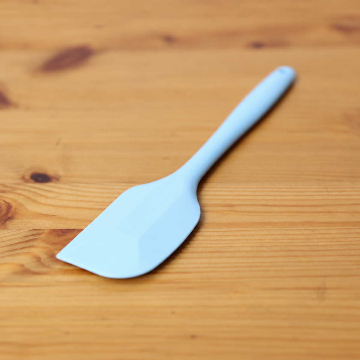 Close-up of the broad blue head of a CakeLand large silicone spatula