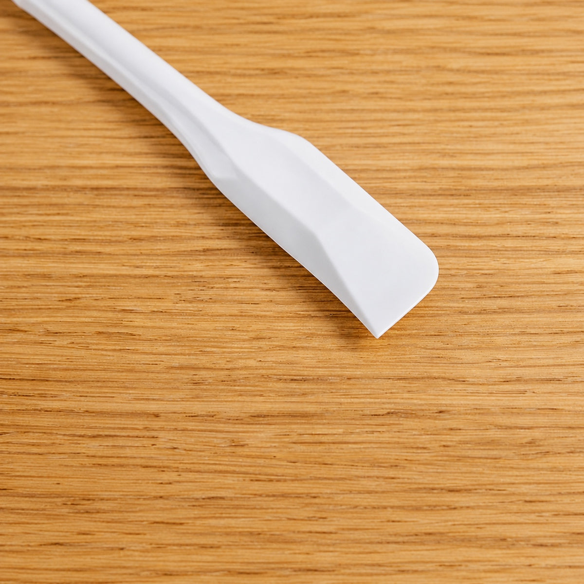 Close-up of the narrow white head of a CakeLand small silicone spatula