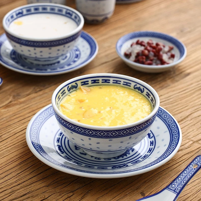 Cantonese desserts served in blue-and-white Linglong bowls and matching plates on a wooden table