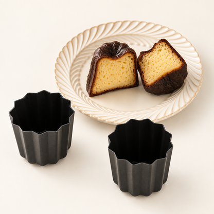 Canelé molds beside a cut canelé showing its custardy centre